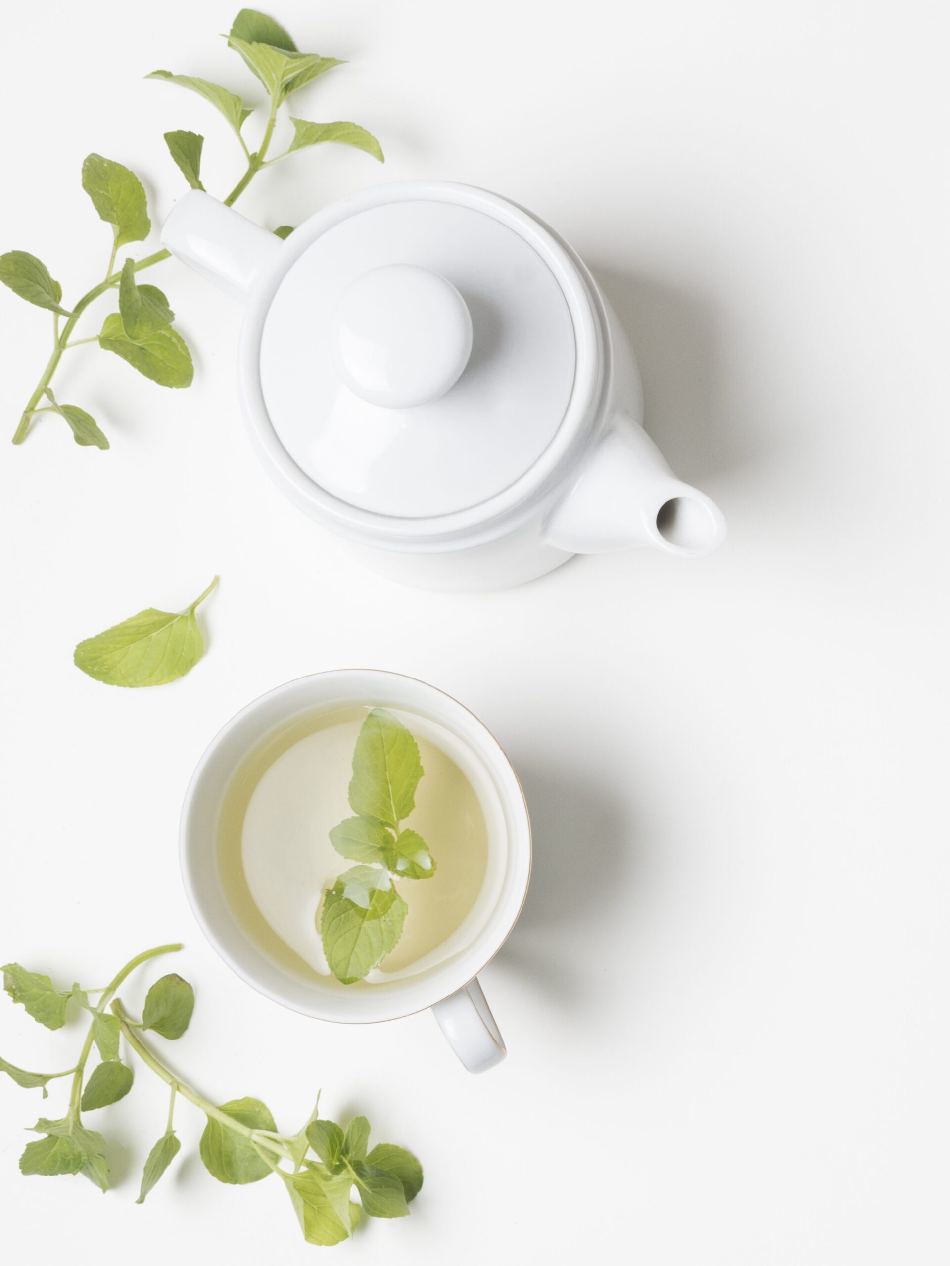 Teapot from the top view with brewed tea and scattered tea leaves